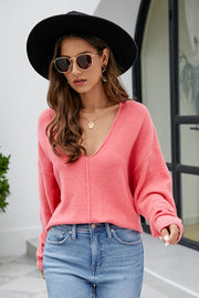 Watermelon pink textured knit pullover sweater with deep V-neck and long sleeves.
