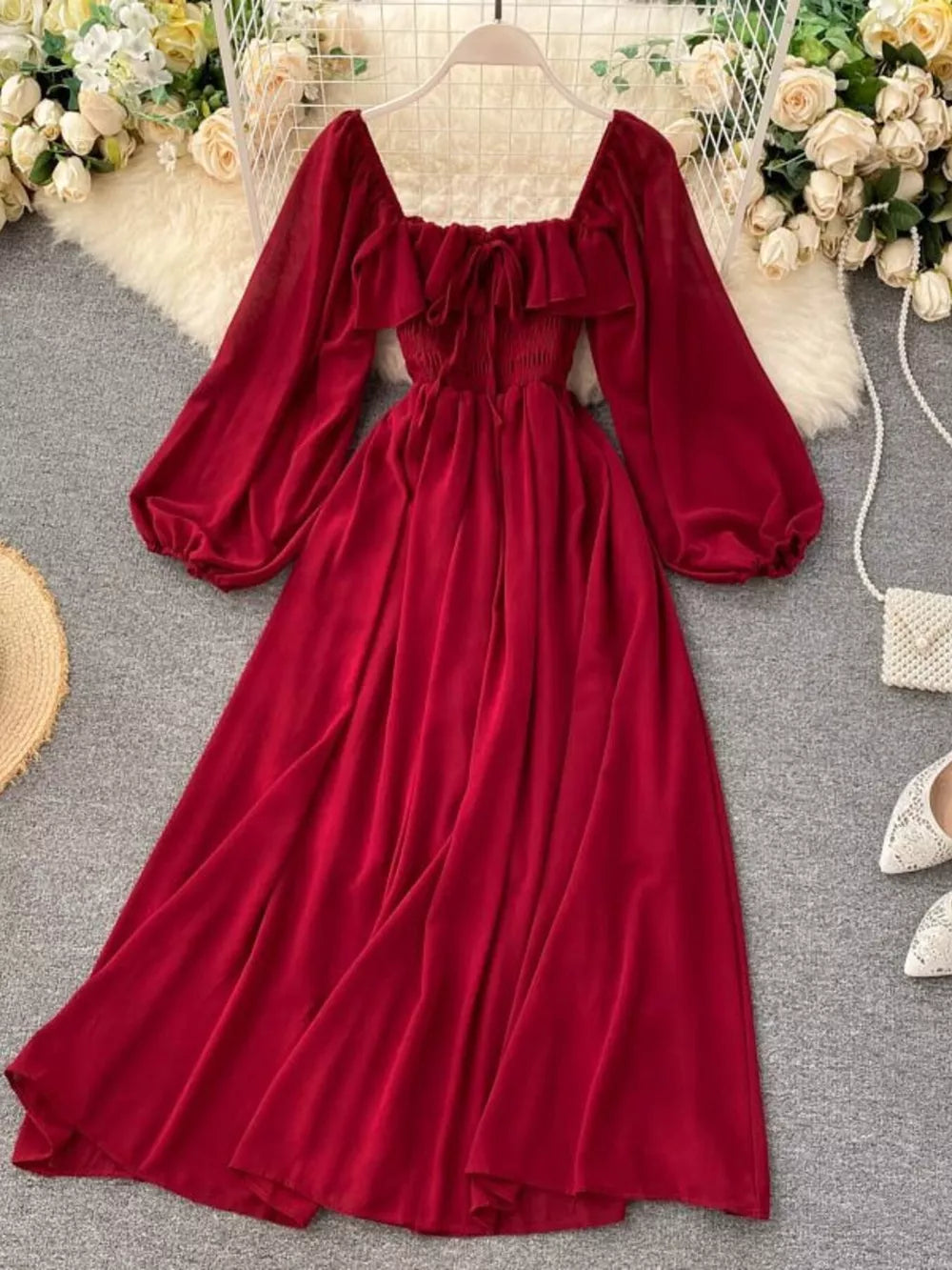 Red maternity dress with square neck, ruffled trim, tie detail, smocked bodice, and balloon sleeves.