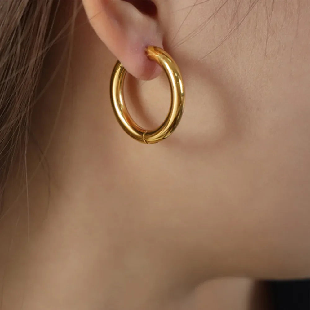 Gold hoop earrings with a sculpted, polished finish.
