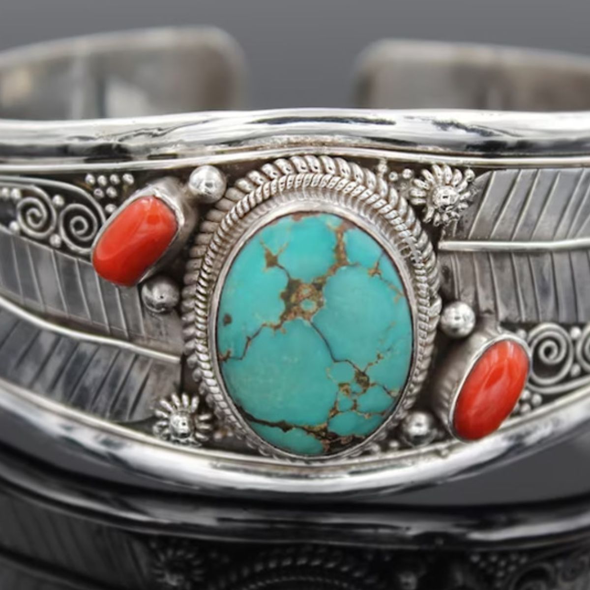 Turquoise and coral cuff bracelet with feather details in sterling silver.