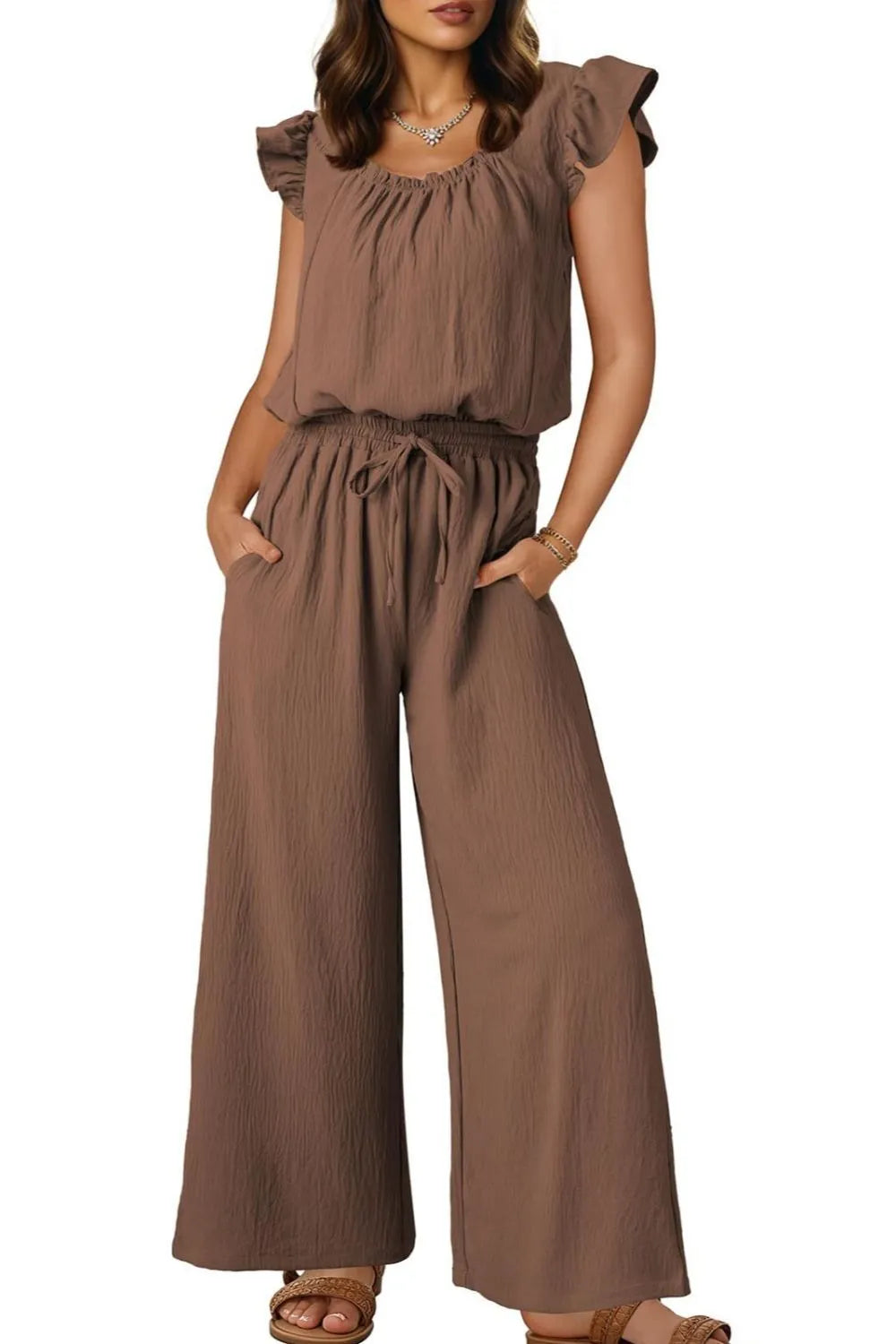 Taupe textured drawstring palazzo jumpsuit with ruffle sleeves and wide legs.