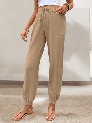 Tan linen-blend joggers with drawstring waist and gathered cuffs.