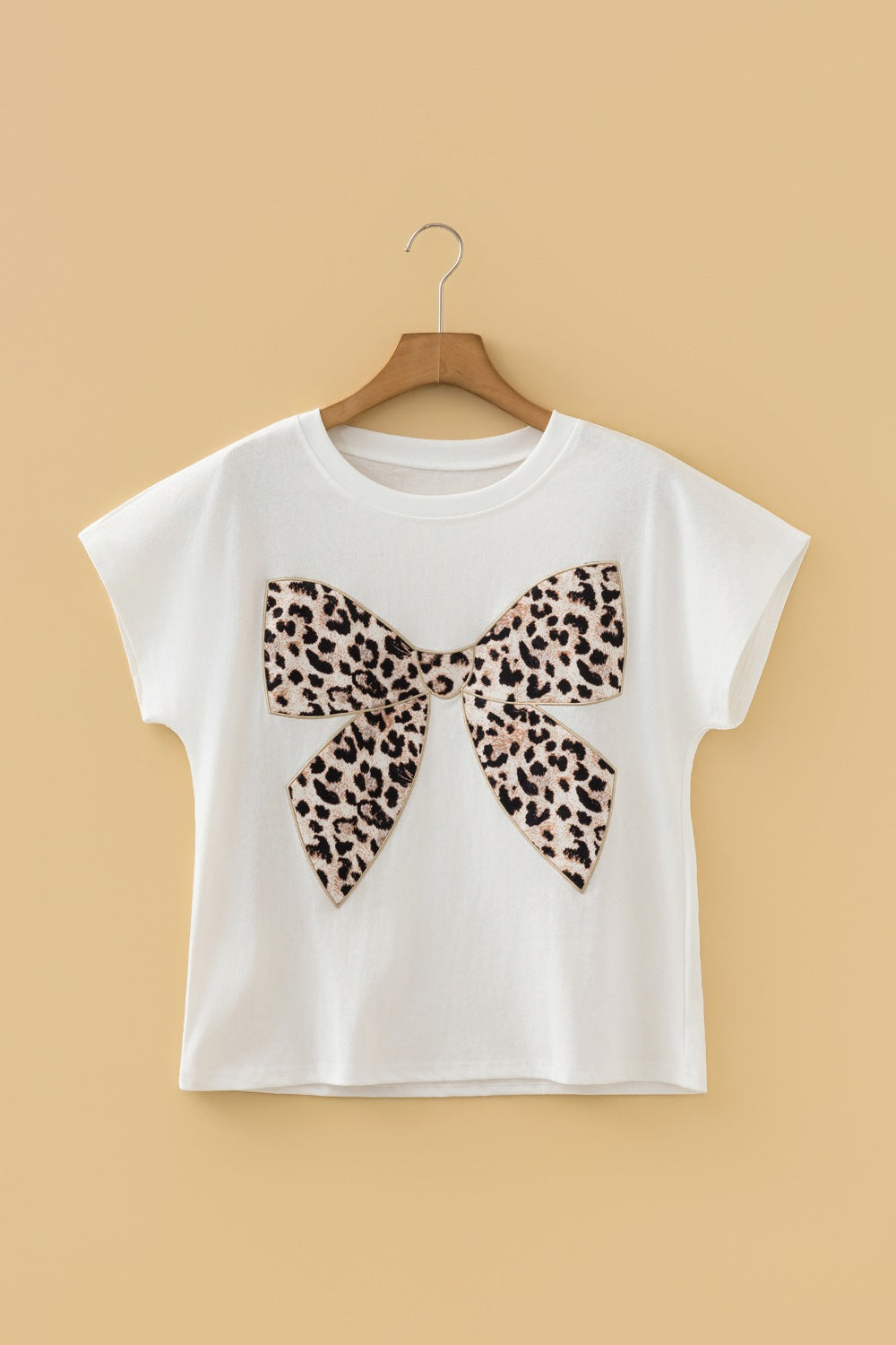 White cotton crew neck t-shirt with a leopard print bow graphic.