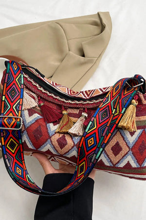 Geometric embroidered shoulder bag in deep red with colorful diamond pattern and tassels.