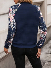 Navy quilted bomber jacket with floral print sleeves and a casual fit.