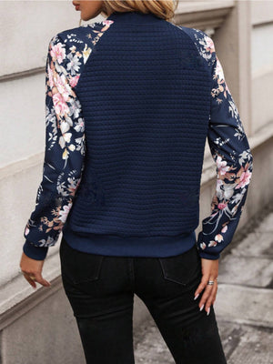 Navy quilted bomber jacket with floral print sleeves and a casual fit.