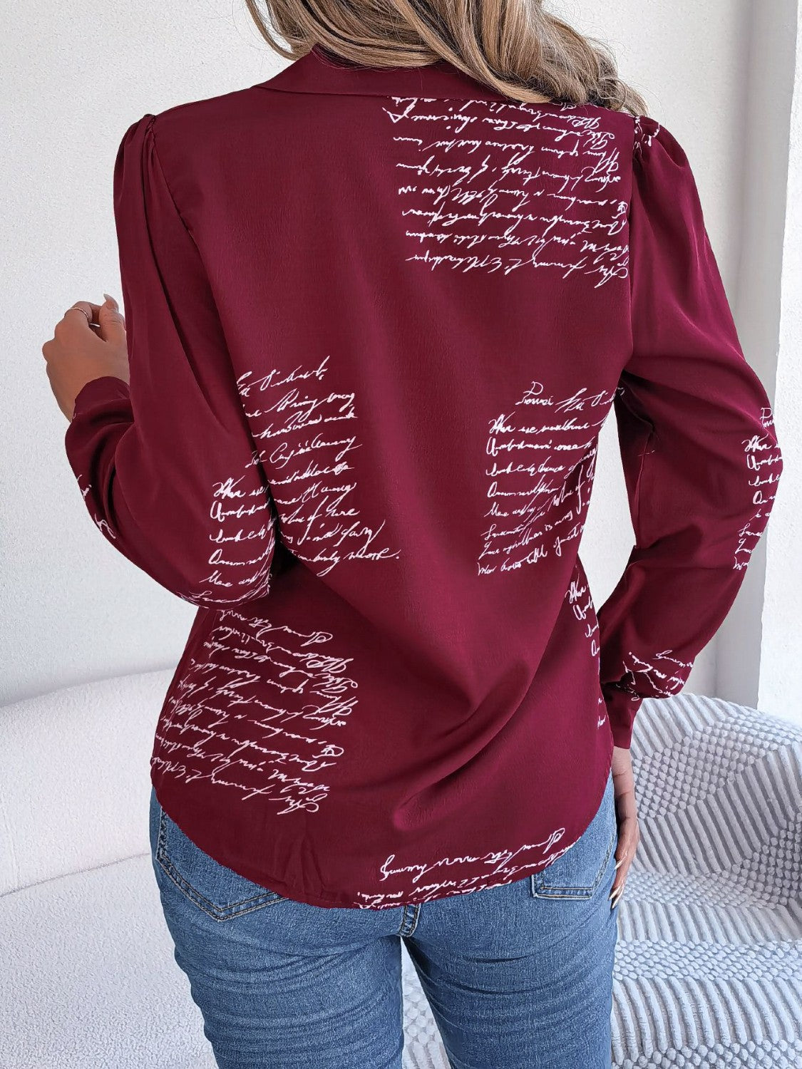 Burgundy collared blouse with white script pattern, long sleeves, and puffed shoulders.