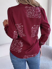 Burgundy collared blouse with white script pattern, long sleeves, and puffed shoulders.