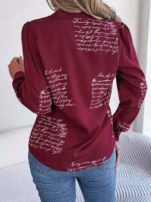 Burgundy collared blouse with white script pattern, long sleeves, and puffed shoulders.