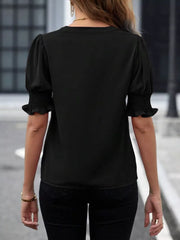 Black blouse with puffed sleeves, smocked cuffs, and a notched neckline.