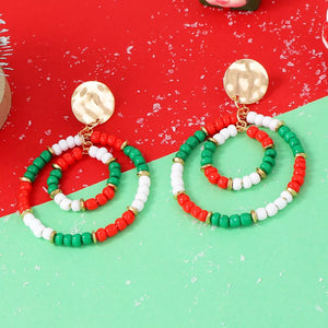 Festive beaded hoop earrings in red, white, and green with gold accents.