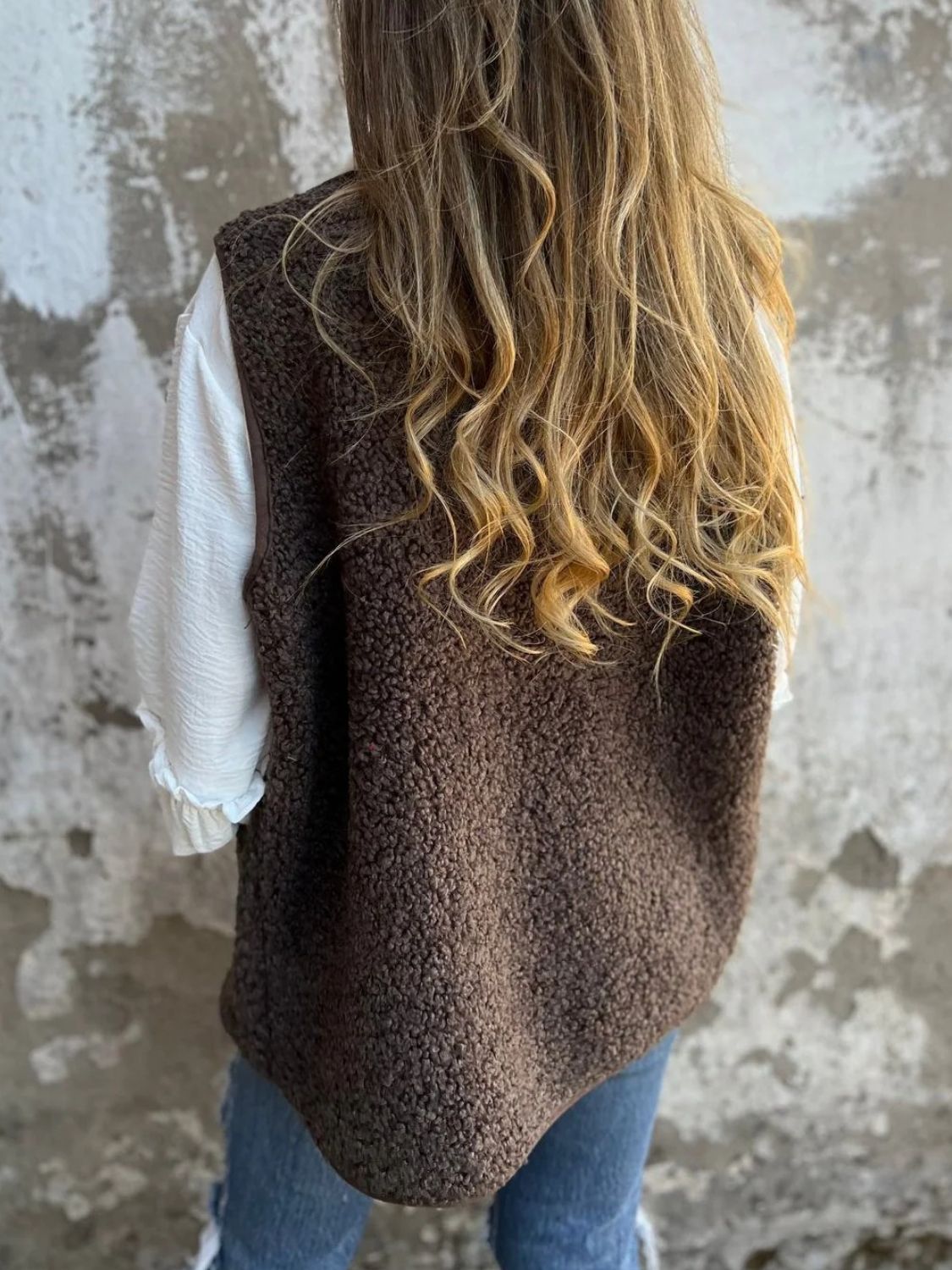 Coffee brown teddy bear vest with leather trim and button closure.