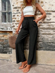Black linen palazzo trousers with drawstring waist and wide legs.