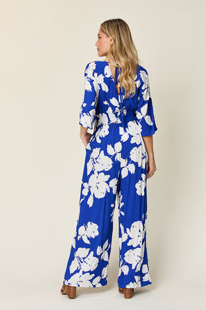 Cobalt blue floral kimono jumpsuit with smocked waist and wide legs.