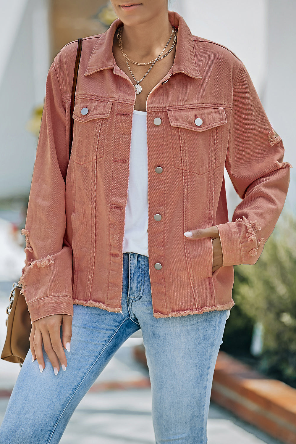 Salmon distressed denim trucker jacket with frayed edges and button front.