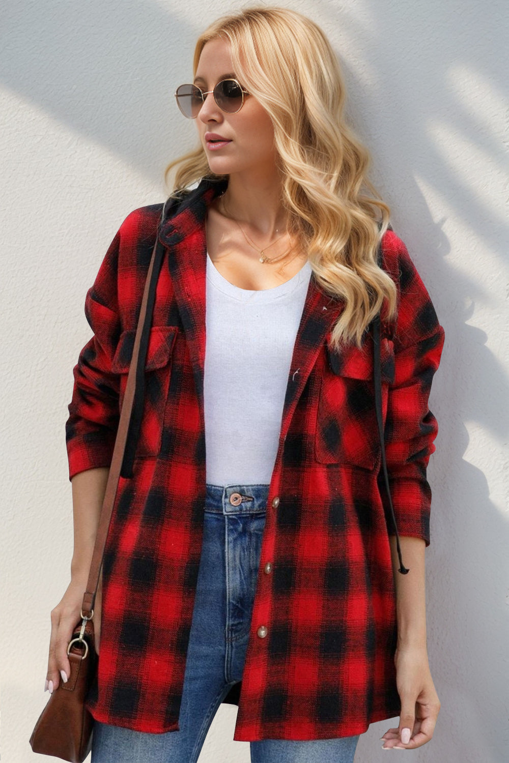 Oversized red and black plaid hooded shirt jacket with buttoned front and chest pockets.