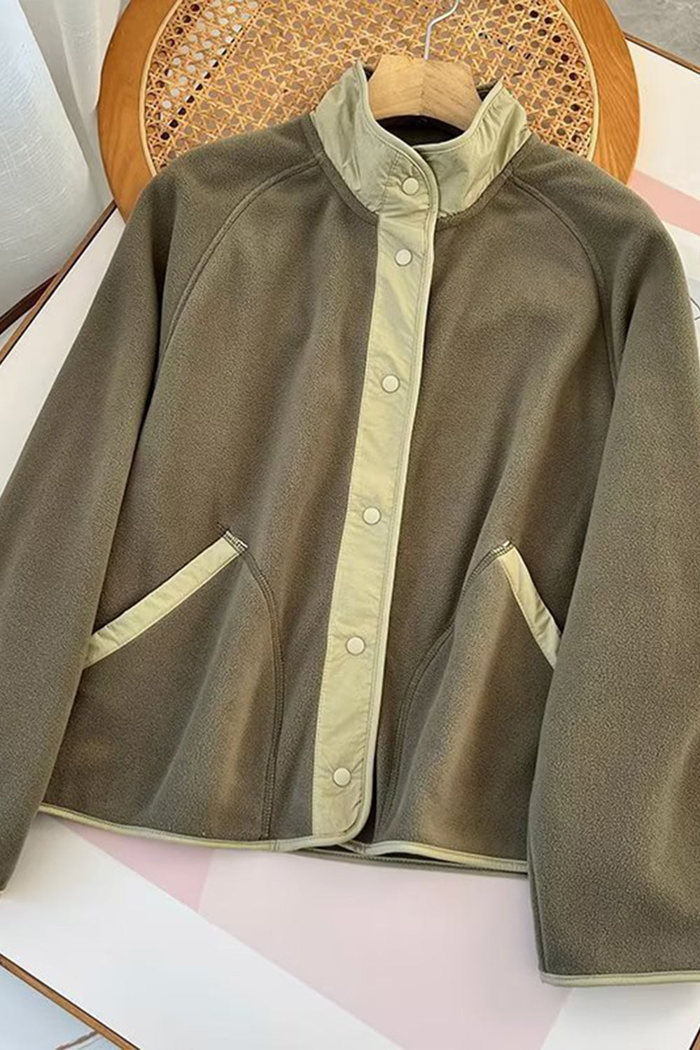 Moss fleece bomber jacket with contrast trim and snap closure.