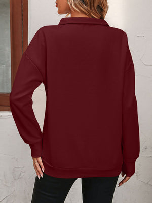 Burgundy quarter-zip sweatshirt with relaxed fit and long sleeves.