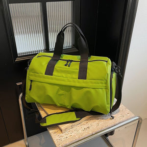 Green nylon travel duffel bag with black straps and zippers, featuring multiple compartments.