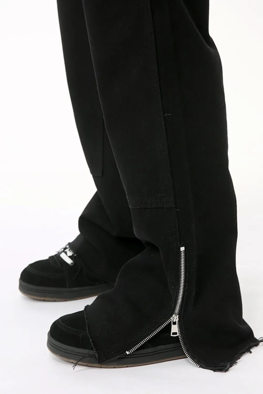 Black bootcut denim pants with zip hem detail and frayed cuffs.
