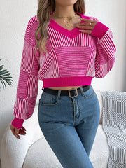 Hot pink and white geometric stripe cropped knit sweater with v-neck and long sleeves.