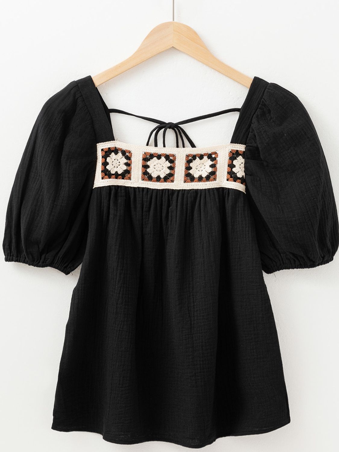 Black gauze blouse with puff sleeves and a square neckline featuring a crochet yoke detail.