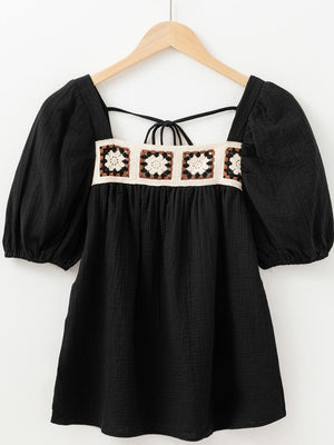 Black gauze blouse with puff sleeves and a square neckline featuring a crochet yoke detail.