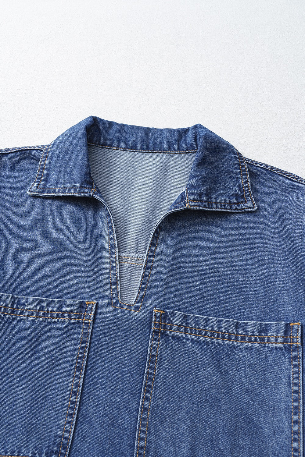 Light blue denim mini dress with collar, V-neck, and two chest pockets.