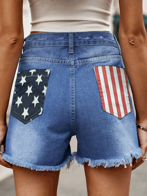 Distressed denim shorts with American flag back pockets and frayed hem.