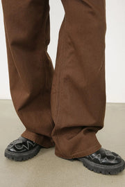 Brown wide-leg denim pants with angled seams and a casual fit.