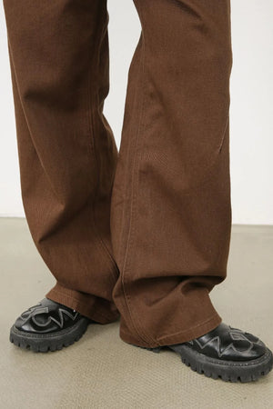 Brown wide-leg denim pants with angled seams and a casual fit.