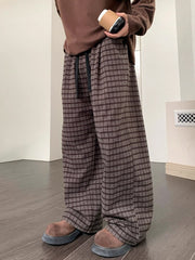 Men's brown plaid wide leg trousers with drawstring waist.