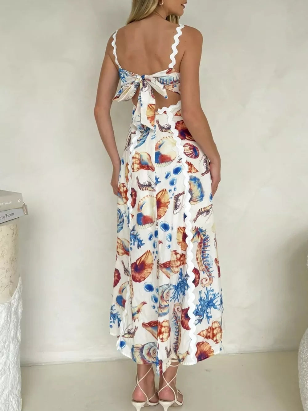 Midi dress with seashell print, scalloped trim, and tie-back detail.