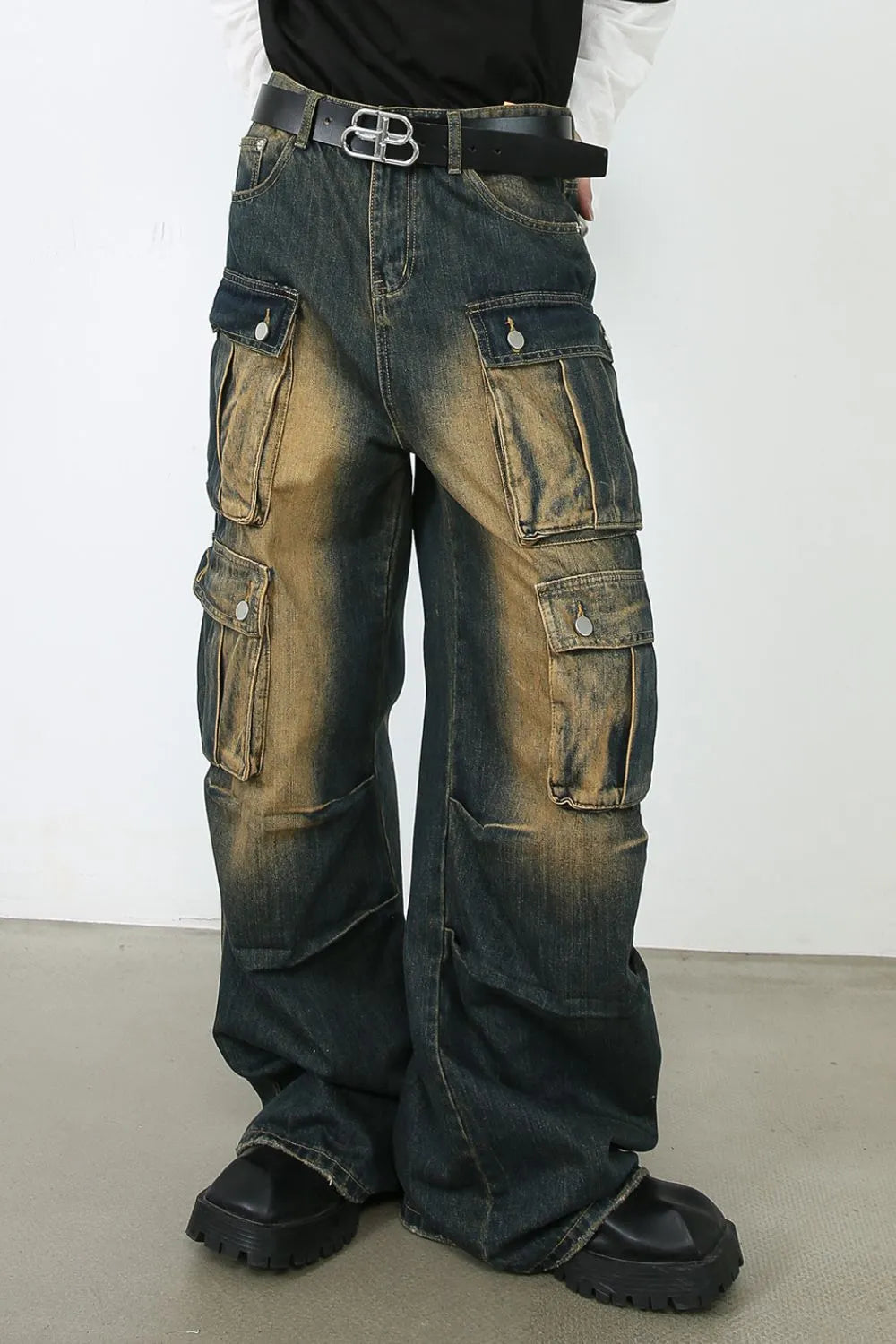 Distressed medium wash denim cargo pants with multiple flap pockets and a relaxed fit.