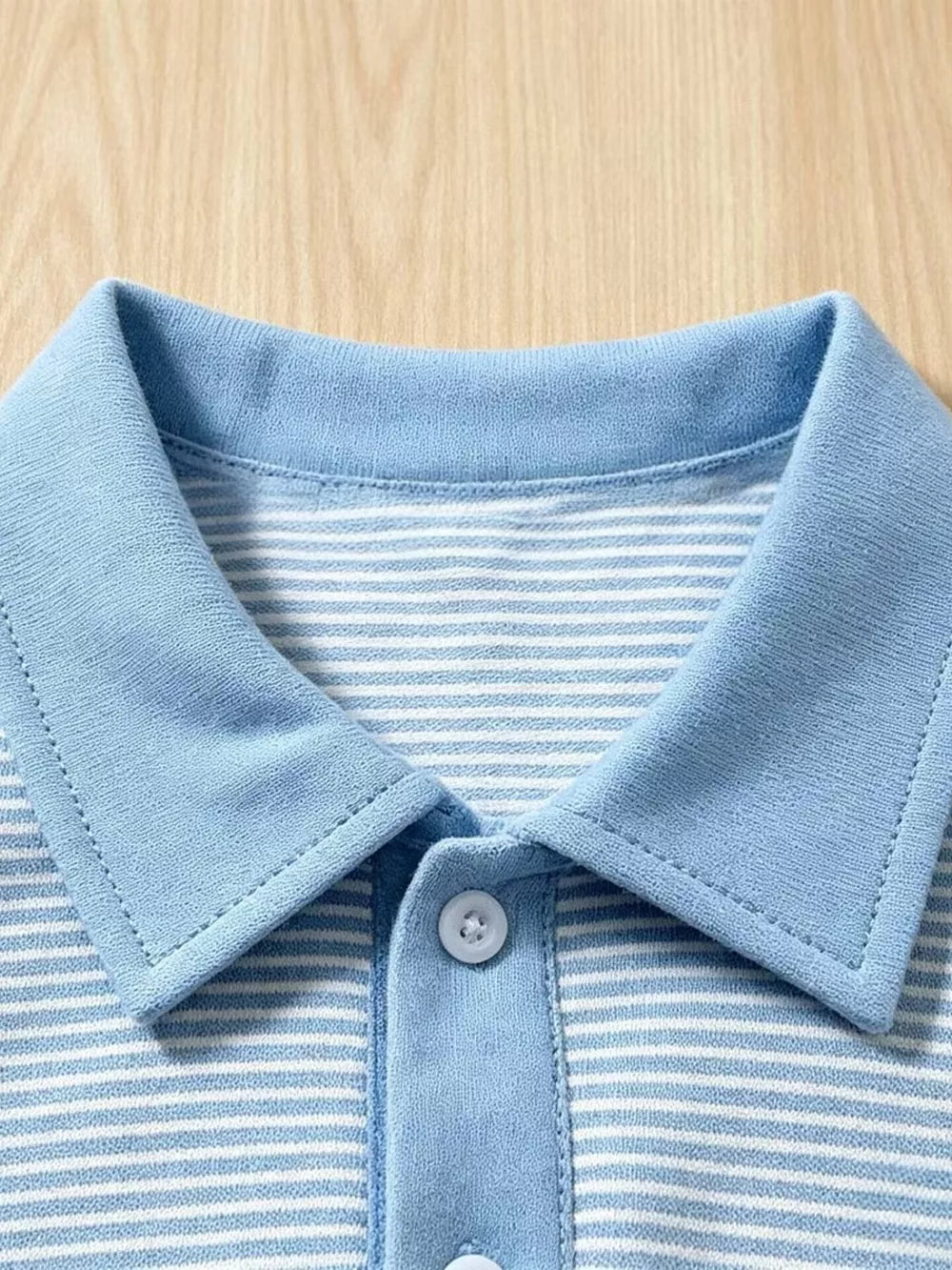 Baby blue and white striped cotton polo shirt with a light blue collar and button placket.