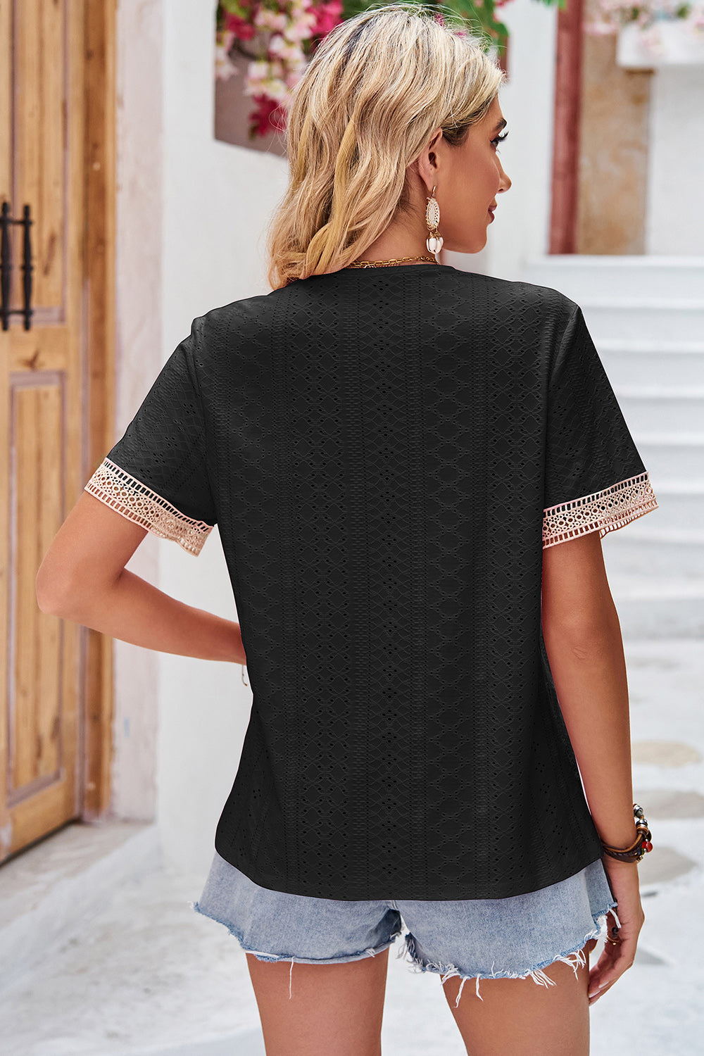 Black eyelet blouse with lace trim on short sleeves and V-neck.