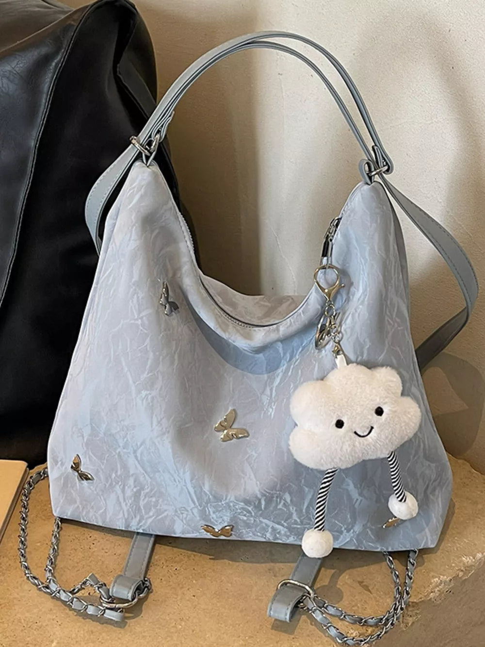 Light blue shoulder bag with butterfly embellishments and cloud charm