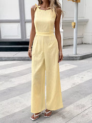 Yellow tie strap wide-leg jumpsuit with subtle floral texture and defined waist