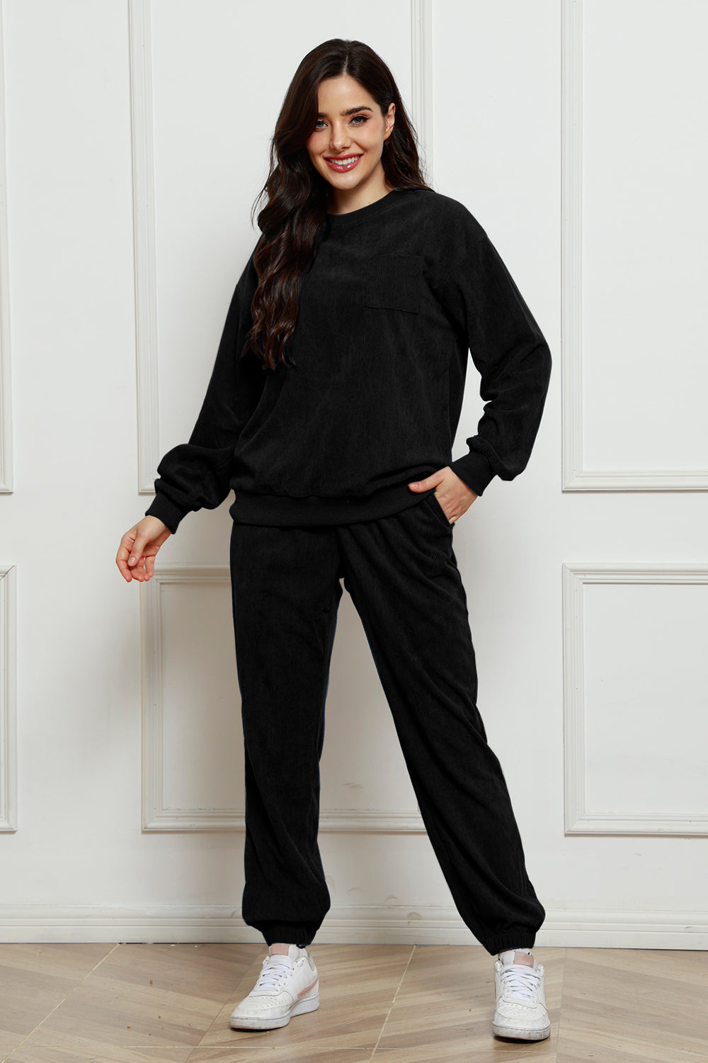 Black corduroy lounge set with crew neck sweatshirt and jogger pants, featuring a chest pocket.
