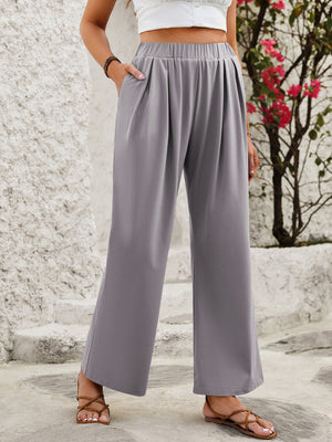 Gray wide leg trousers with elastic waist and pockets, styled with sandals.