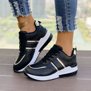 Black lace-up sneakers with metallic accents and a chunky white sole.