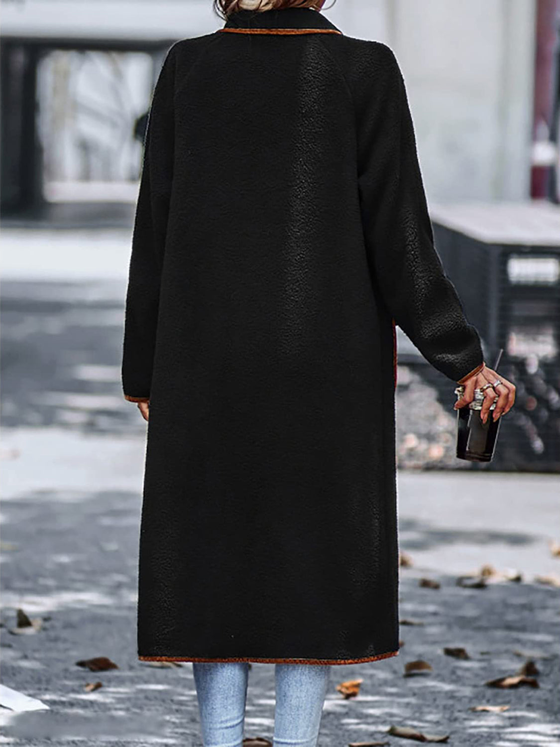 Black teddy coat with contrast trim detailing and long sleeves.