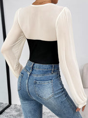 Black and white long-sleeve mesh bodysuit with ribbed black panel, styled with jeans.
