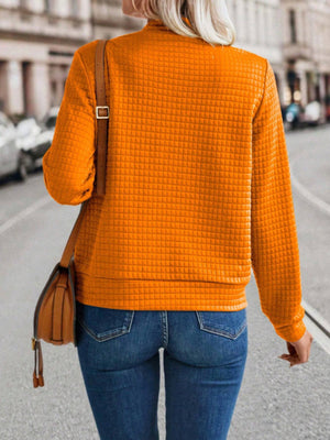 Quilted bomber jacket in Tangerine with a textured grid pattern and zip closure.