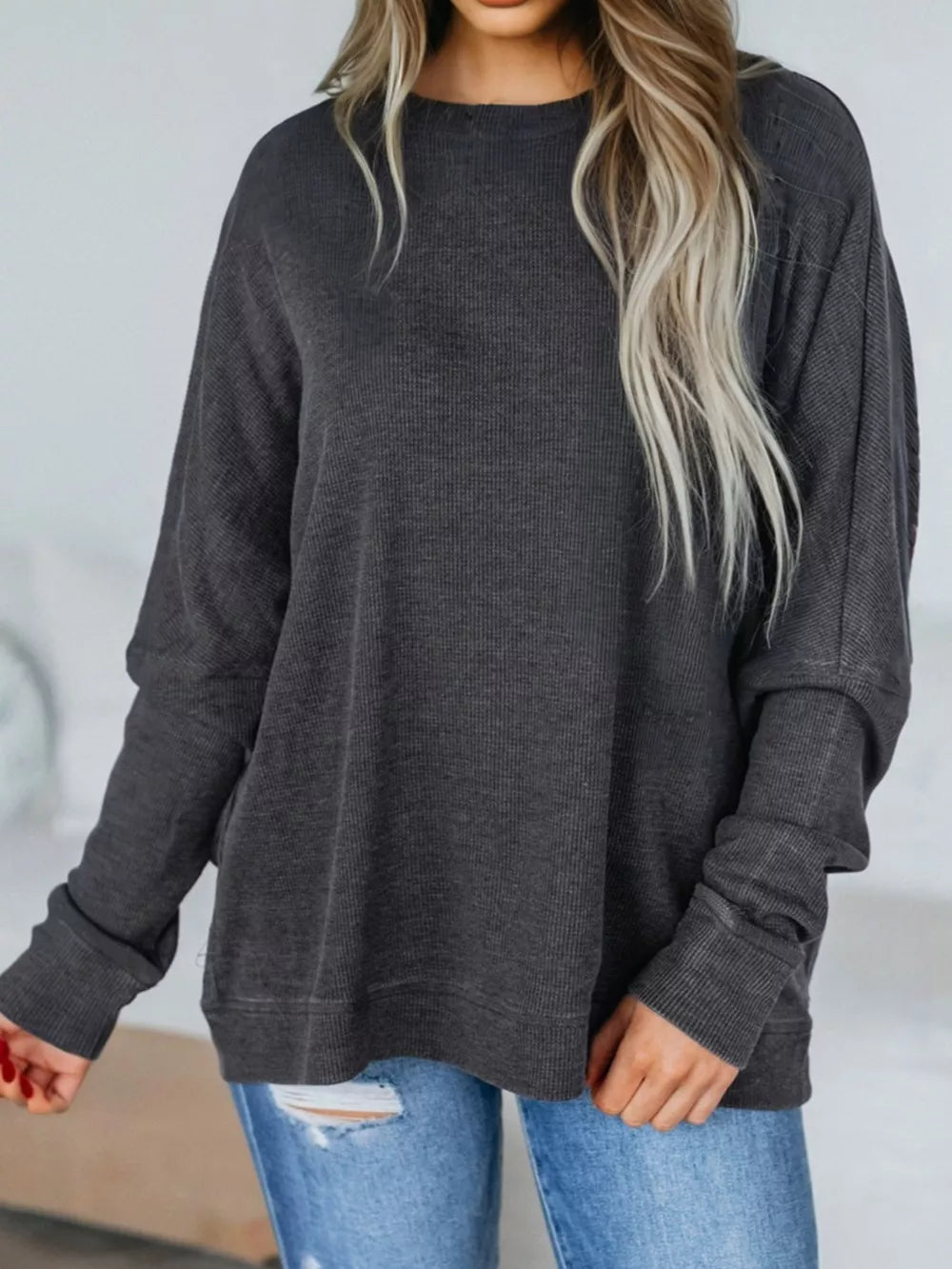 Dark gray waffle knit oversized sweatshirt with crew neck and long sleeves.