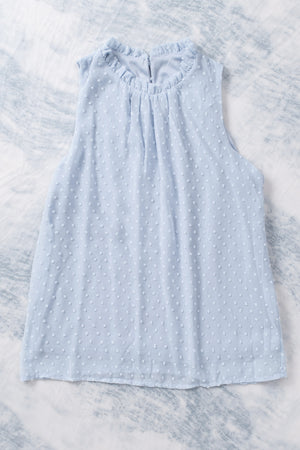 Light blue textured tank top with ruffled halter neckline and allover dot pattern.
