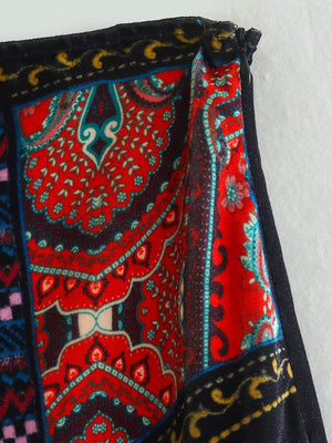Velvet mini skirt with bold red and blue patchwork embroidery and a black waistband.