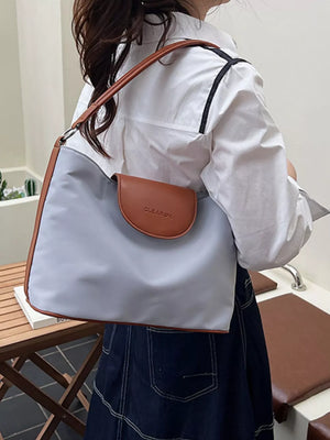 Chic canvas hobo crossbody bag in gray with brown trim and flap.