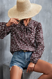 Brown abstract print pussy bow blouse with balloon sleeves.