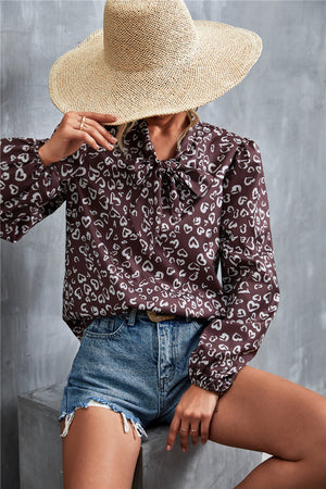 Brown abstract print pussy bow blouse with balloon sleeves.